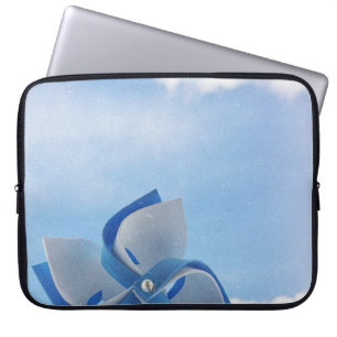 Witte en blauwe handheld windmolen onder troebele  laptop sleeve