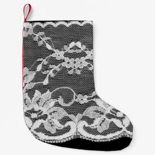 Witte florale kant op een zwarte achtergrond. kleine kerstsok