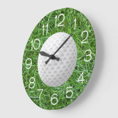Witte golfbal op groen gras grote klok (Hoek)