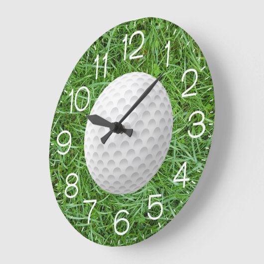 Witte golfbal op groen gras grote klok (Hoek)
