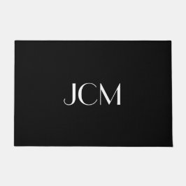 Witte initiële monogram op zwart deurmat