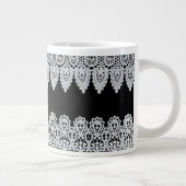 Witte kant vormt een delicate grens tegen zwart grote koffiekop (Rechts)