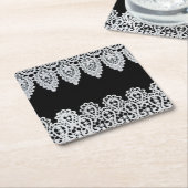 Witte kant vormt een delicate grens tegen zwart kartonnen onderzetters (Schuin)