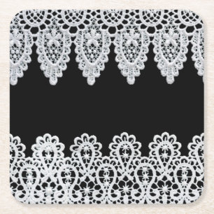 Witte kant vormt een delicate grens tegen zwart kartonnen onderzetters