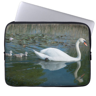 Witte knobbelzwaan met baby eendachtige jongen op  laptop sleeve
