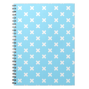Witte kruisstiften op babyblauw notitieboek