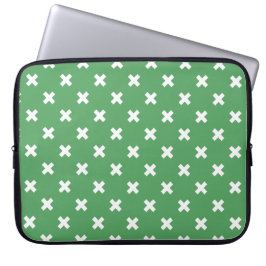Witte kruisstiften op groen laptop sleeve