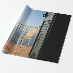 Witte metalen armstoel naast hek 's ochtends cadeaupapier