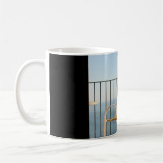 Witte metalen armstoel naast hek 's ochtends koffiemok