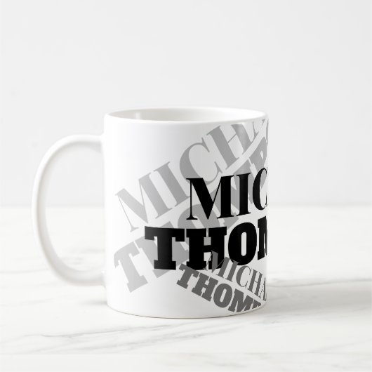 witte mok met zwarte grijze, vetgedrukte lettertyp (Links)