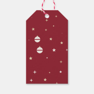 Witte ornamenten en sterren op rood cadeaulabel