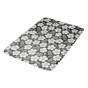 Witte parels in bloemen op zwart badmat
