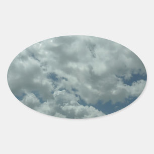 Witte, pluizige wolken aan de blauwe hemel ovale sticker
