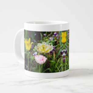 Witte, roze en gele tulpen in de tuin grote koffiekop