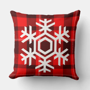 Witte sneeuwvlok op een klassiek rood tartanpatroo kussen