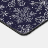 Witte sneeuwvlokken op blauw bureaumat (Hoek)