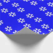 Witte sneeuwvlokken op blauw cadeaupapier (Hoek)