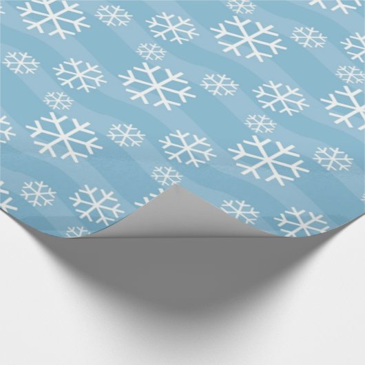 Witte sneeuwvlokken op blauw cadeaupapier (Hoek)