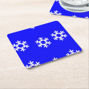 Witte sneeuwvlokken op blauw kartonnen onderzetters