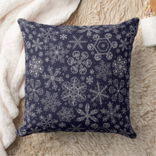 Witte sneeuwvlokken op blauw kussen