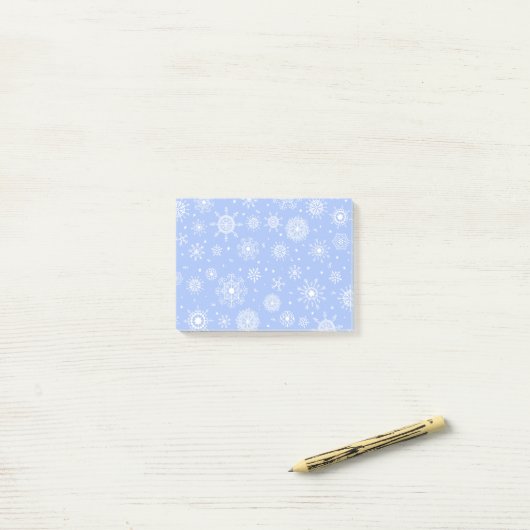 Witte sneeuwvlokken op blauw post-it® notes (Op bureau)