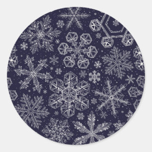 Witte sneeuwvlokken op blauw ronde sticker