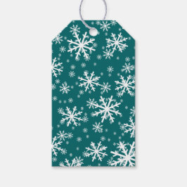 Witte sneeuwvlokken op donker aquablauw cadeaulabel