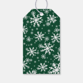 Witte sneeuwvlokken op donker groenblijvend groen cadeaulabel