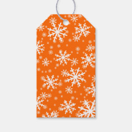 Witte sneeuwvlokken op oranje cadeaulabel