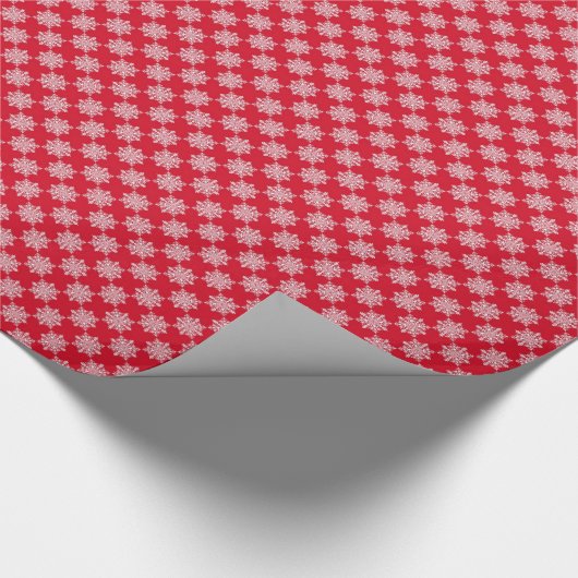 Witte sneeuwvlokken op rood cadeaupapier (Hoek)