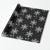 Witte sneeuwvlokken op zwarte kerst cadeaupapier (Uitgerold)