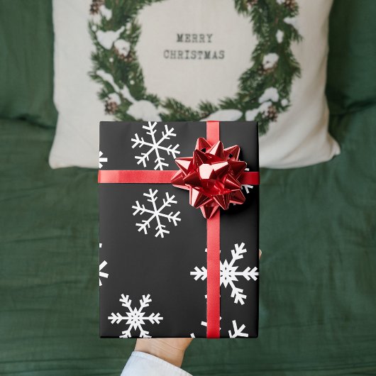 Witte sneeuwvlokken op zwarte kerst cadeaupapier