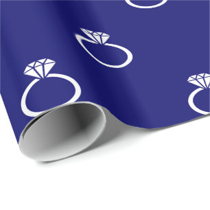 Witte verlovingsringen op marineblauw cadeaupapier