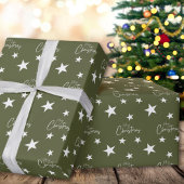 Witte vrolijke kerststerren op groen cadeaupapier