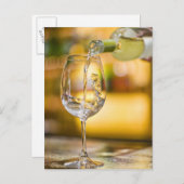 Witte wijn wordt uit de fles gegoten in het restau briefkaart (Voorkant / Achterkant)