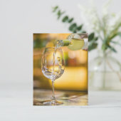 Witte wijn wordt uit de fles gegoten in het restau briefkaart (Staand voorkant)