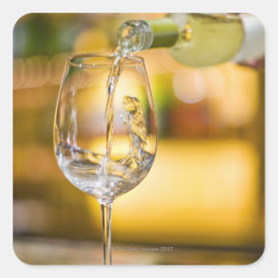Witte wijn wordt uit de fles gegoten in het restau vierkante sticker