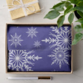 Witte wintersneeuwvlokken op blauw tissuepapier (Geschenk)
