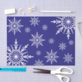 Witte wintersneeuwvlokken op blauw tissuepapier (Craft)
