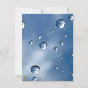 Wolken weerspiegeld in dauwdruppels tegen een blau briefkaart