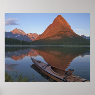 Wooden kayak in het Swiftcurrent Lake bij zonsopga Poster
