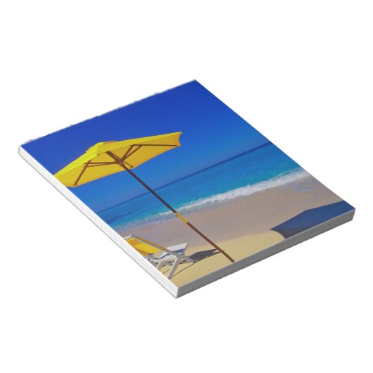 Yellow beach umbrella and chairs on prisping notitieblok (Schuin)