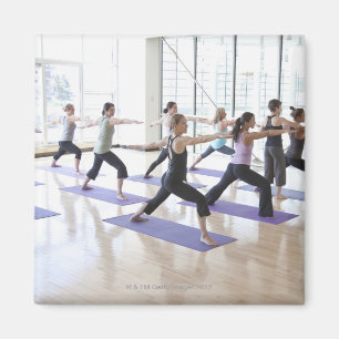 Yoga-docent onderwijst een klasse vrouwen de magneet