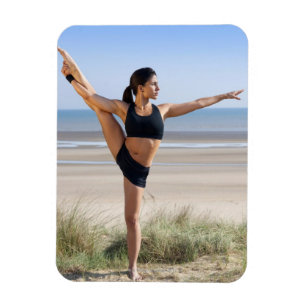 yoga wordt op het strand geoefend door een vrouw magneet