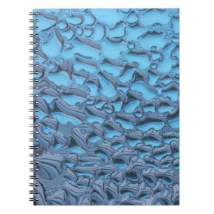 Zachte regendruppels op blauw notitieboek van glas