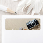 Zandachtergrond. Concept met oude retro camera Etiket (Insitu)