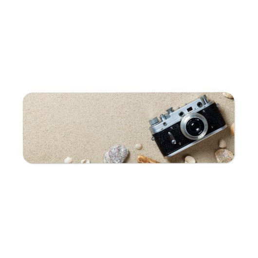 Zandachtergrond. Concept met oude retro camera Etiket (Voorkant)