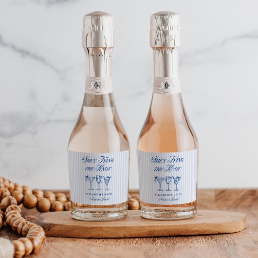 Ze bindt de knoop aan een elegante hand getekend sparkling wijnetiket