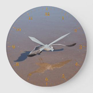 Zeegelaars reflecteren en schaduwen op het strand grote klok