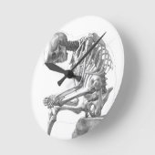 Zittend  skelet denken ronde klok (Hoek)